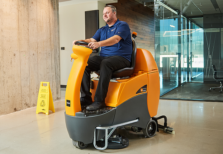 man driving a floor cleaner